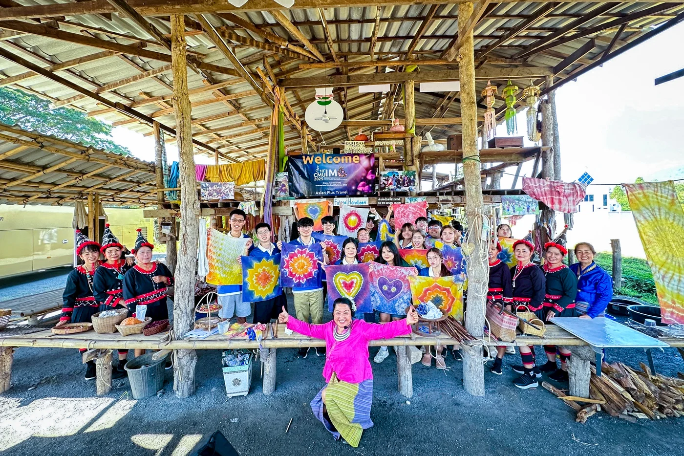Local hosts and visitors displaying colorful tie-dye creations at a community workshop