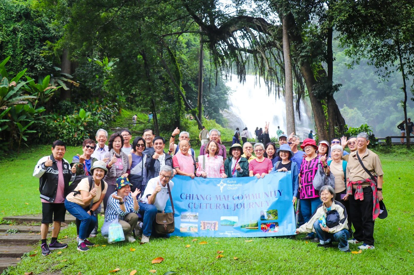 APT travel group visiting a waterfall surrounded by forest